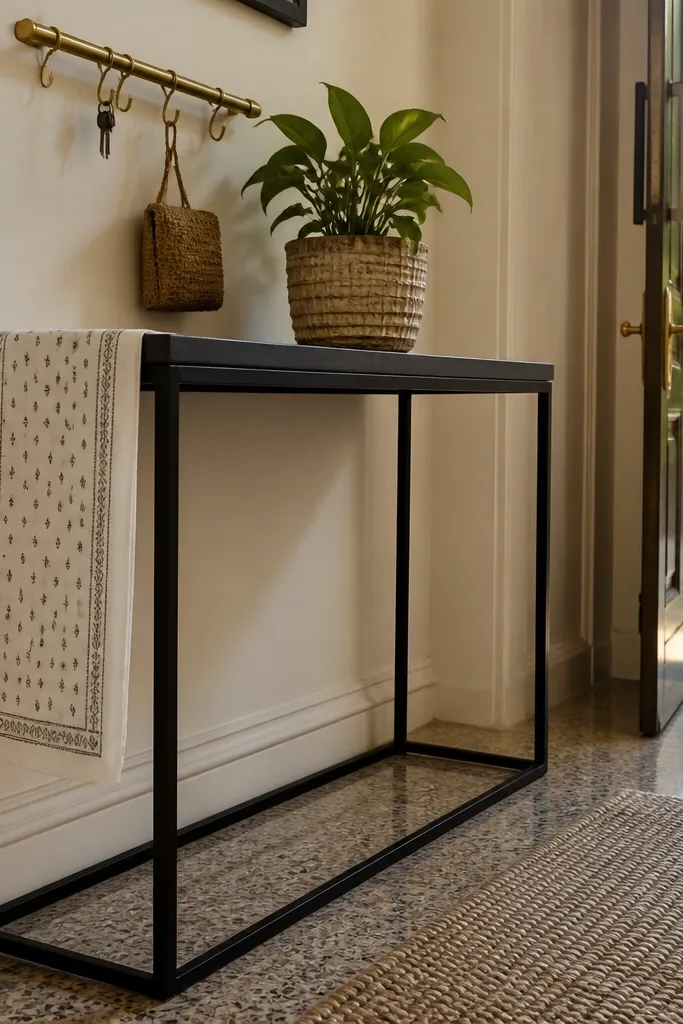 Black metal console with a block-print runner and white ceramic decor