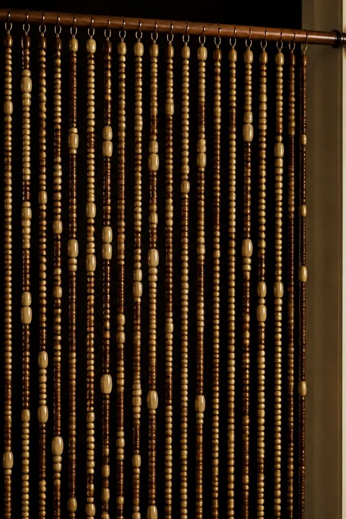Bead curtain hanging in front of a solid curtain strip dividing a bedroom nook