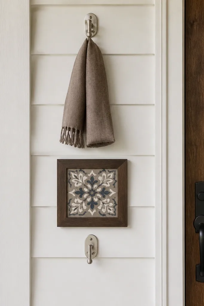 Wall hooks with a small welcome sign aligned vertically near the front door
