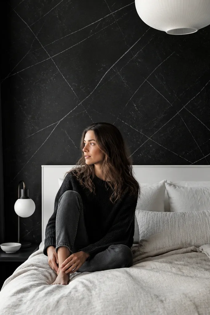 Black marble-look wall film behind a bed with white bedding